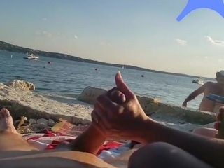 On a nude beach the wife stokes my cock while a voyuer watches